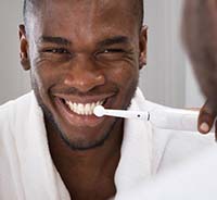 Man brushing his teeth to prevent dental emergencies in Auburn