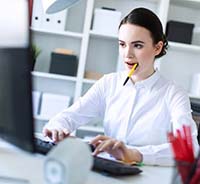 Businesswoman chewing on pencil headed for dental emergency in Auburn