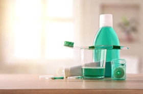 Variety of green oral hygiene tools resting on countertop