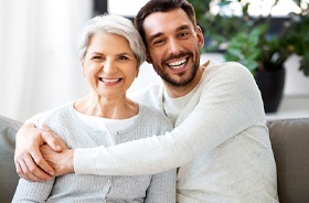 Senior woman and adult son, both candidates for dental implants