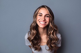 Woman smiling after following dental implant post-op instructions in Auburn