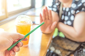 Woman saying no to straw after implant surgery