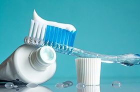 Close-up of toothbrush and toothpaste next to drops of water