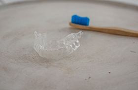 Invisalign aligner next to toothbrush