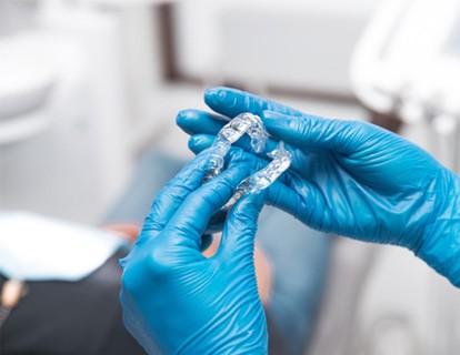 Dentist holding Invisalign aligners
