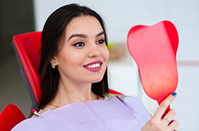 Patient smiling while looking at mirror