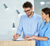 Man signing paperwork in dental office