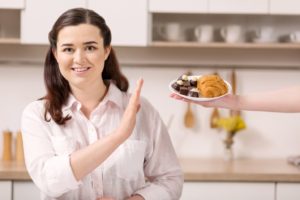 woman saying no thanks to treats after dental implant surgery