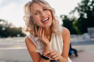 Woman showing offer her smile after free teeth whitening treatment