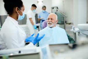 Senior man talking to dentist about denture sores