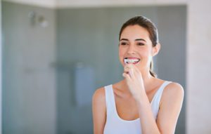 Beautiful young woman brushing her teeth