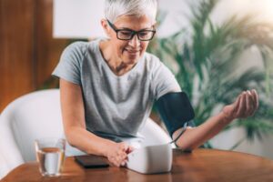 Senior woman checking her blood pressure at home