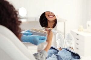 Dental patient admiring her smile after teeth whitening treatment 