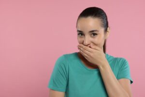 Embarrassed woman covering her mouth 