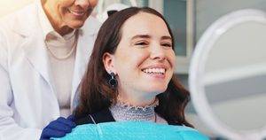 Cosmetic dentistry patient looking at herself in mirror